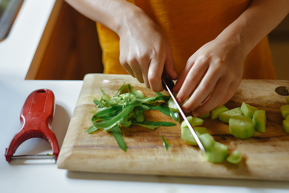Cook chopping vegetables on a cutting board